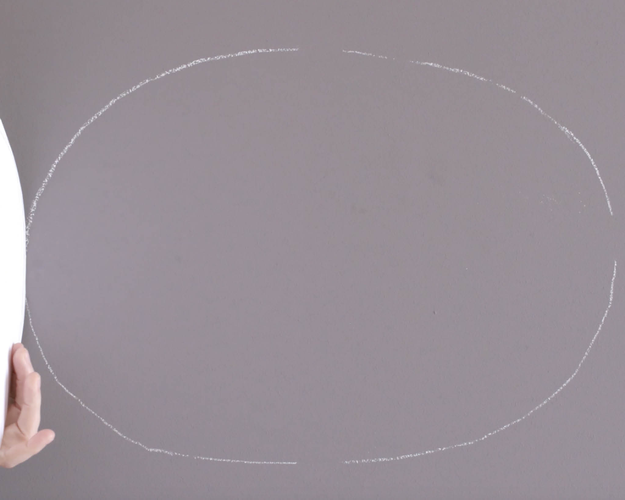 Chalked oval on wall Use chalk to draw around your oval shape